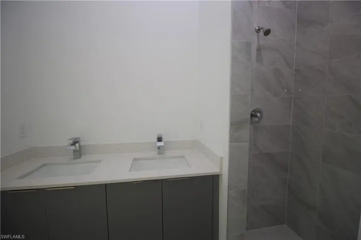 Bathroom featuring vanity and a tile shower