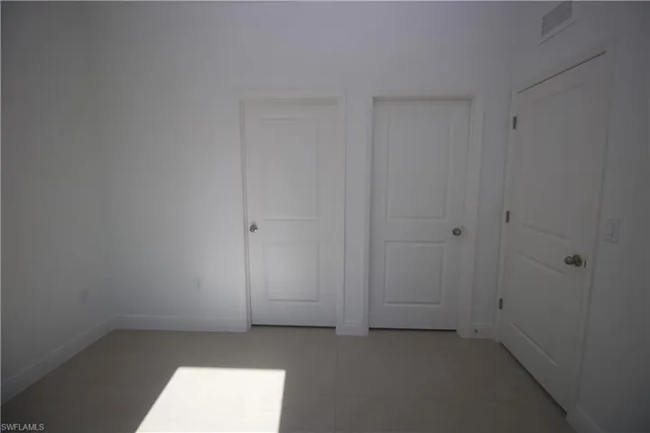 Bedroom featuring light tile patterned flooring and a closet