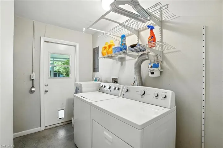 Laundry room with washing machine and clothes dryer and electric panel