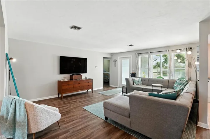Living area with dark wood-style flooring and baseboards