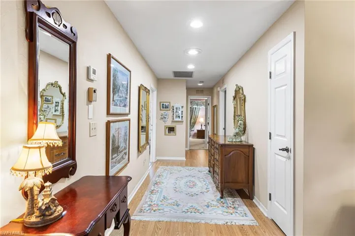 Corridor with light wood-style flooring and recessed lighting