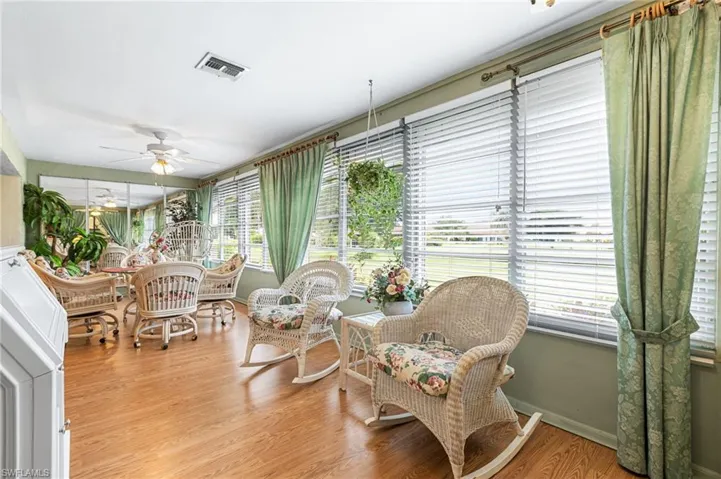 Sunroom with wood finished floors and baseboards
