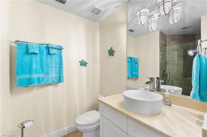 Full bath featuring a stall shower, vanity, and light tile patterned floors