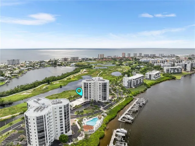 View of urban area with a nearby body of water and a pool