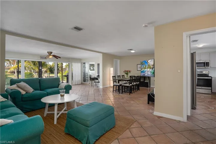 Living room with ceiling fan and light tile patterned flooring