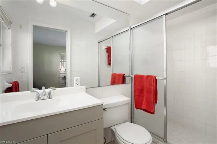 Bathroom with tile patterned flooring, vanity, an enclosed shower, and toilet