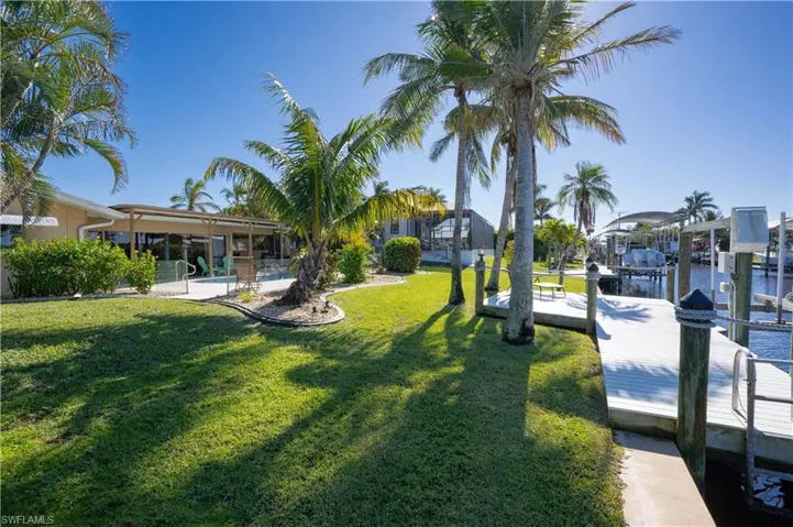 View of dock with a yard and a water view