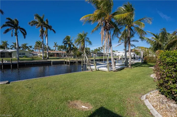 View of dock with a water view and a yard