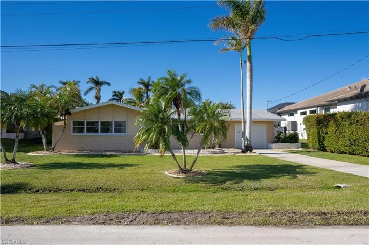 Ranch-style house with a garage and a front yard