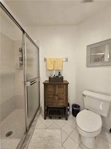 Bathroom with a stall shower, vanity, and light tile patterned floors