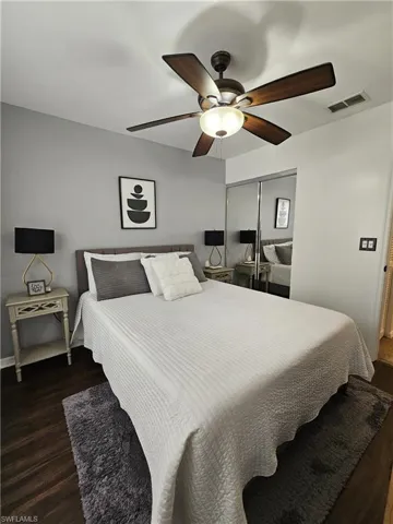 Bedroom featuring dark wood-style floors, a closet, and ceiling fan