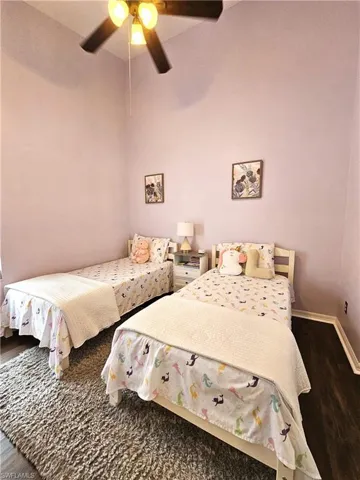 Bedroom with dark wood-style floors and a ceiling fan
