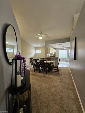 Dining space featuring a ceiling fan, dark carpet, and plenty of natural light