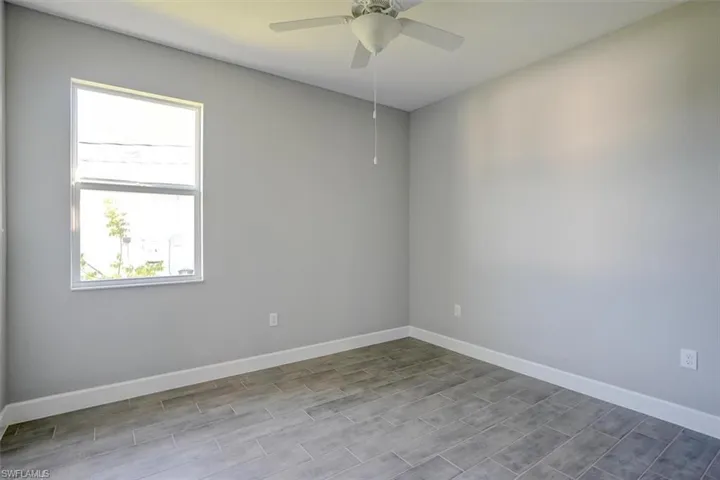Empty room with hardwood / wood-style flooring and ceiling fan