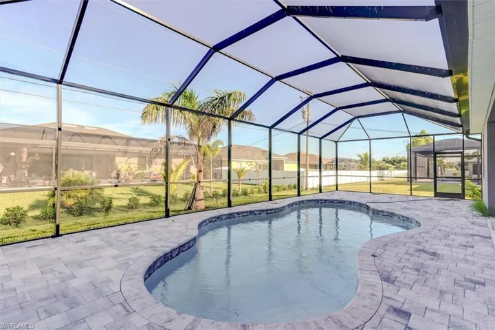 View of swimming pool with a patio, glass enclosure, and a lawn
