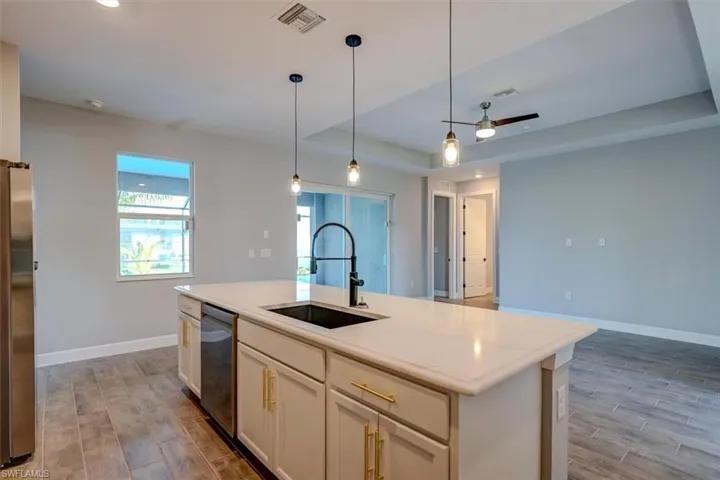 Kitchen featuring stainless steel appliances, a center island with sink, hardwood / wood-style flooring, sink, and pendant lighting