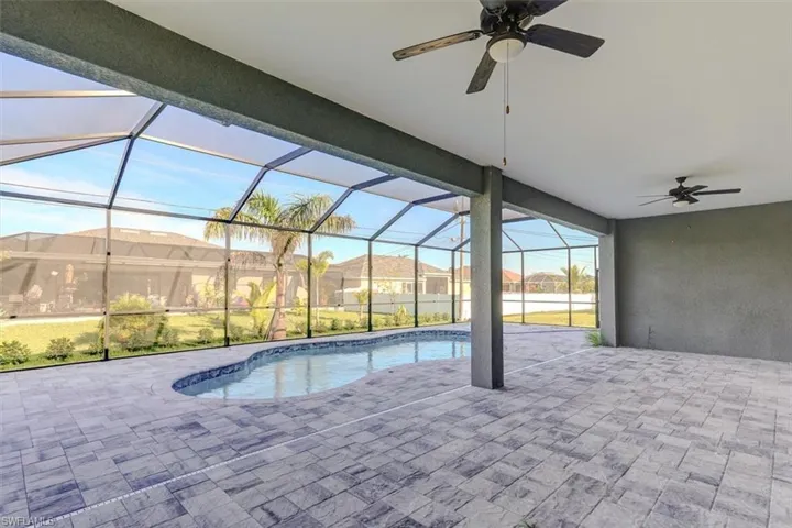View of swimming pool with a lanai, a patio area, and ceiling fan