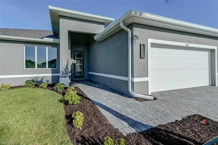 View of front of property featuring a front yard and a garage