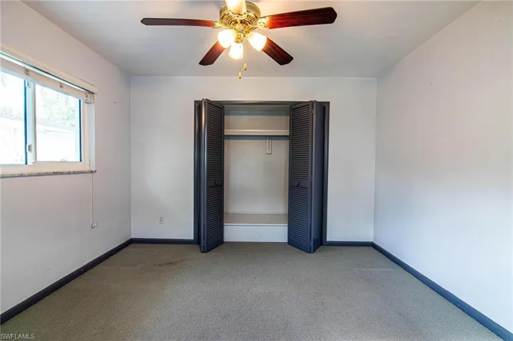 Unfurnished bedroom featuring carpet flooring, ceiling fan, and a closet
