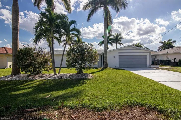 Ranch-style home with a front lawn, driveway, and an attached garage