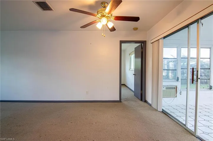 Carpeted spare room with a ceiling fan and baseboards