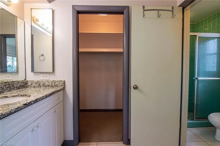 Bathroom with vanity, a shower stall, and light tile patterned floors