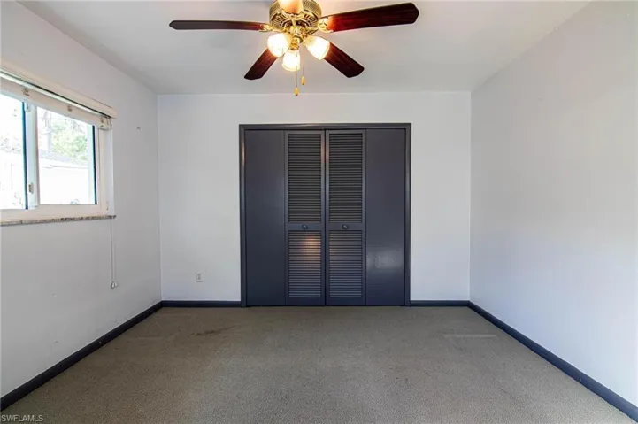 Unfurnished bedroom with carpet flooring, a ceiling fan, and a closet