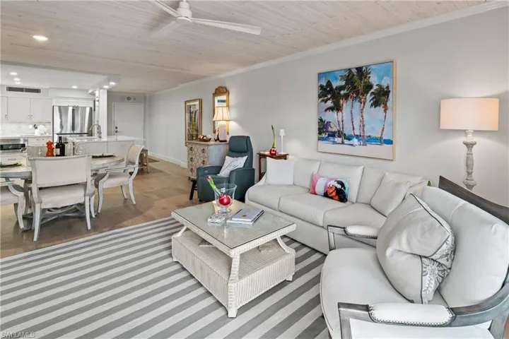 Living room featuring ornamental molding, hardwood / wood-style flooring, ceiling fan, and wooden ceiling