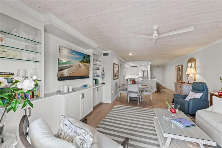 Living room with ceiling fan, built in features, ornamental molding, light hardwood / wood-style floors, and wood ceiling