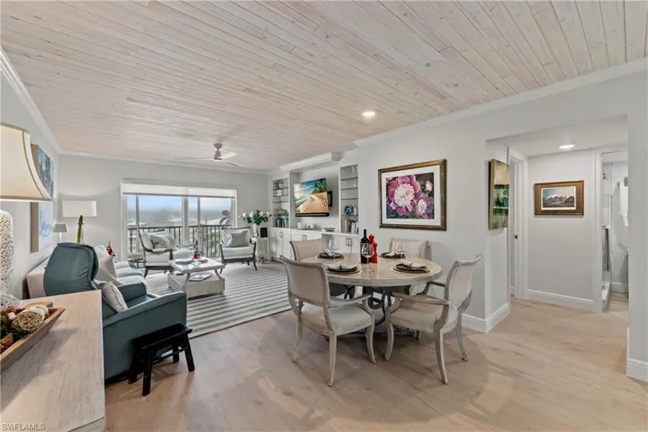 Dining room with light hardwood / wood-style flooring, ceiling fan, crown molding, and wood ceiling