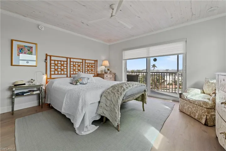 Bedroom featuring ceiling fan, wooden ceiling, access to outside, hardwood / wood-style flooring, and ornamental molding