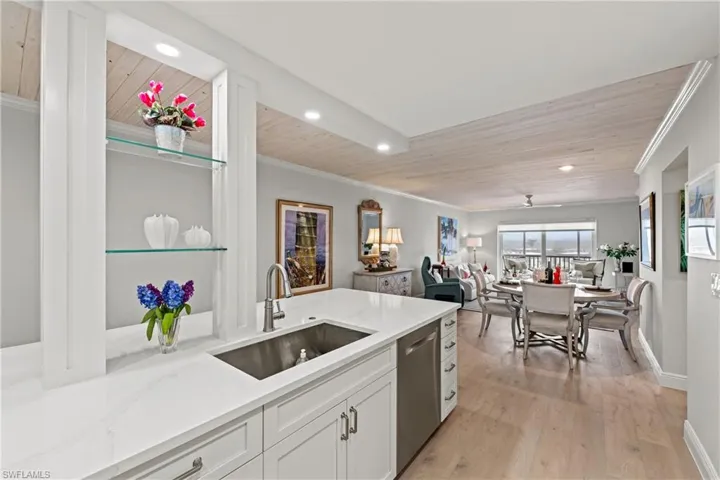 Kitchen featuring white cabinets, dishwasher, wooden ceiling, and sink