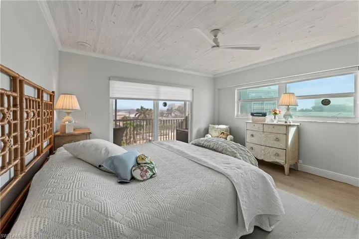 Bedroom with access to exterior, ornamental molding, ceiling fan, light hardwood / wood-style flooring, and wooden ceiling
