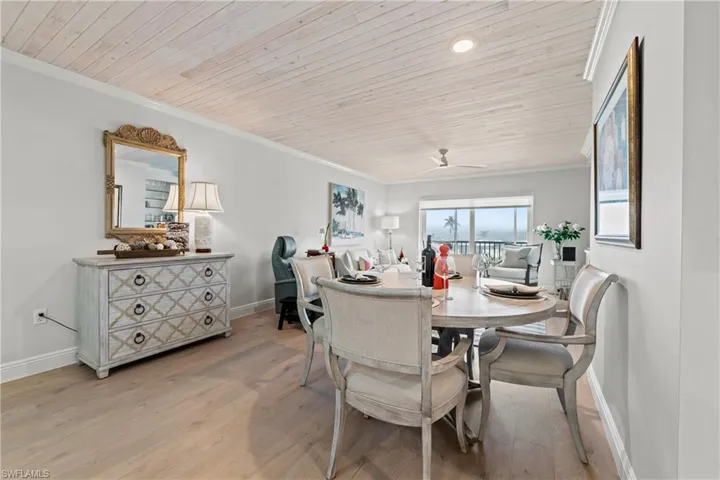 Dining space with light wood-type flooring, crown molding, ceiling fan, and wooden ceiling