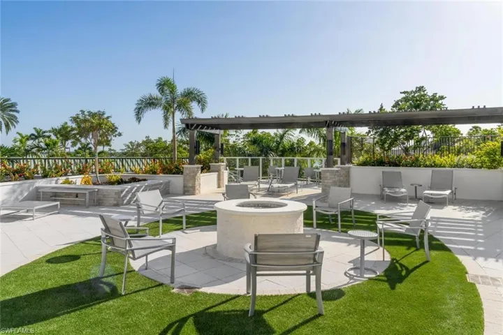 Scenic patio with fire pit surrounded by lush greenery.