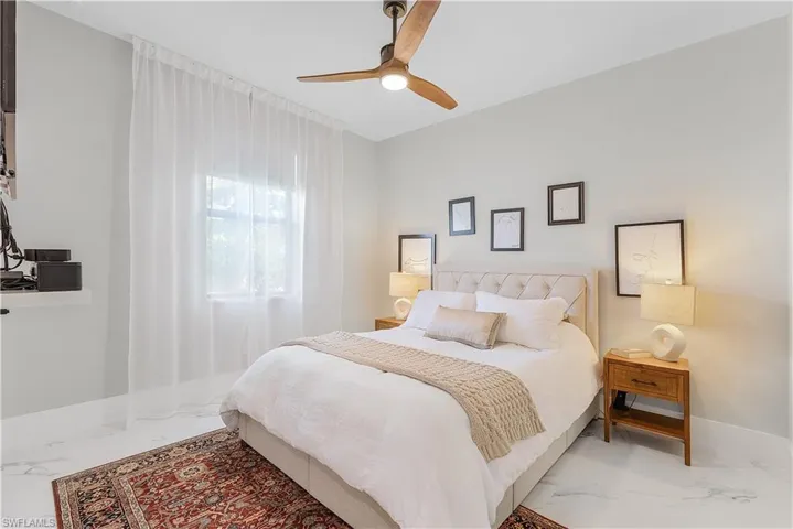 Tiled bedroom featuring ceiling fan