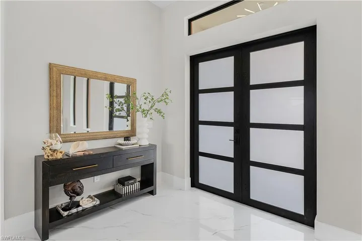 Doorway with a high ceiling and light tile patterned flooring