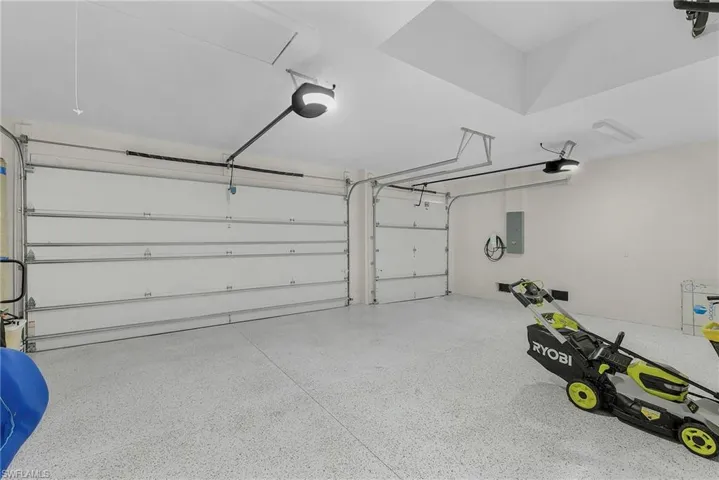 Garage featuring a garage door opener and electric panel