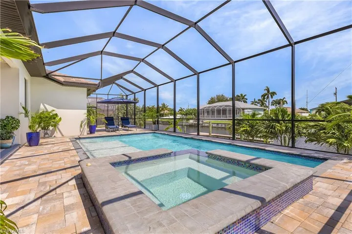 View of swimming pool featuring an in ground hot tub, a patio area, and a lanai