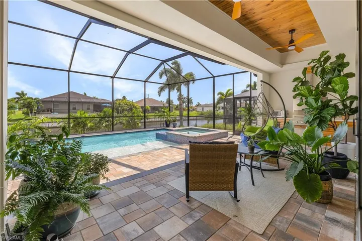 View of swimming pool with an in ground hot tub, a patio area, a lanai, and ceiling fan