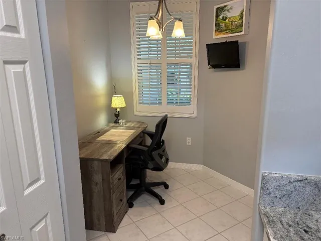 Home office with a chandelier and light.