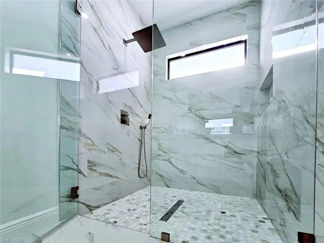 Bathroom featuring a marble finish shower