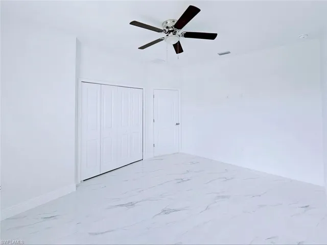 Empty room featuring visible vents, baseboards, marble finish floor, and ceiling fan
