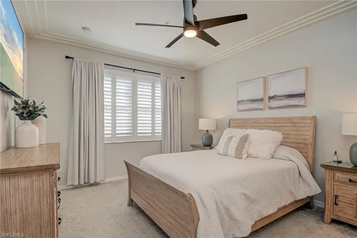 Bedroom featuring ceiling fan, light colored carpet, and crown molding