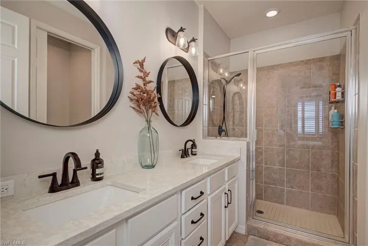Full bath with a stall shower and double vanity