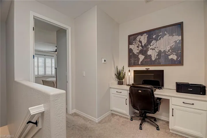 Home office featuring light colored carpet and ceiling fan