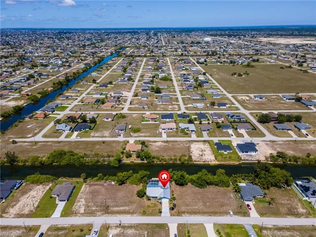 Aerial perspective of suburban area featuring a nearby body of water