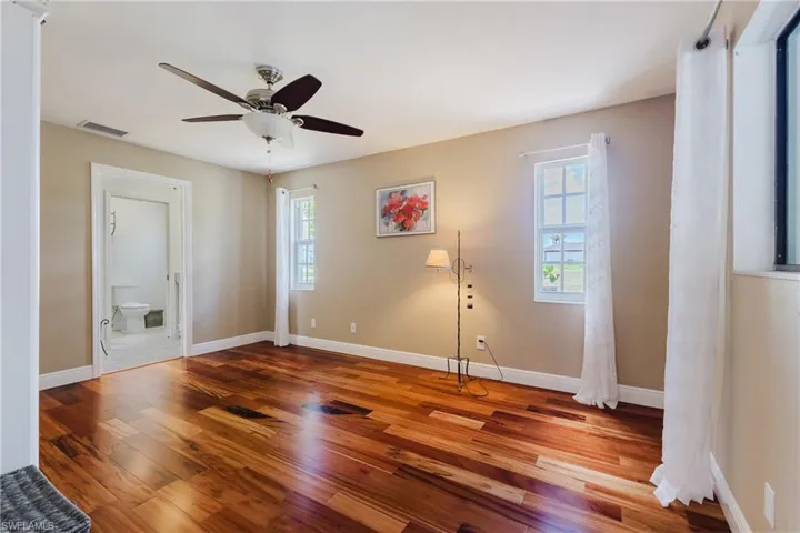 Unfurnished room with a ceiling fan, wood finished floors, and baseboards