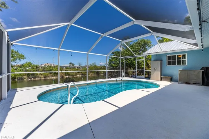 Outdoor pool with a patio area, a lanai, and a water view