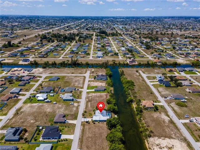 Aerial view of property and surrounding area with nearby suburban area